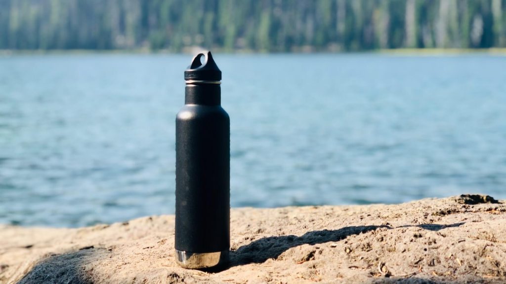 A reusable water bottle with a metal lid.